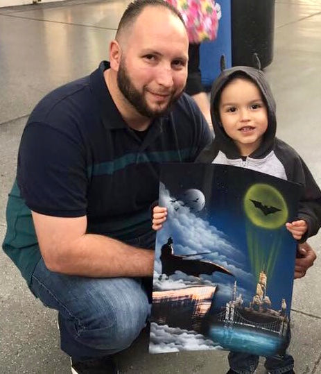 Father and child holding a VegasSprays painting