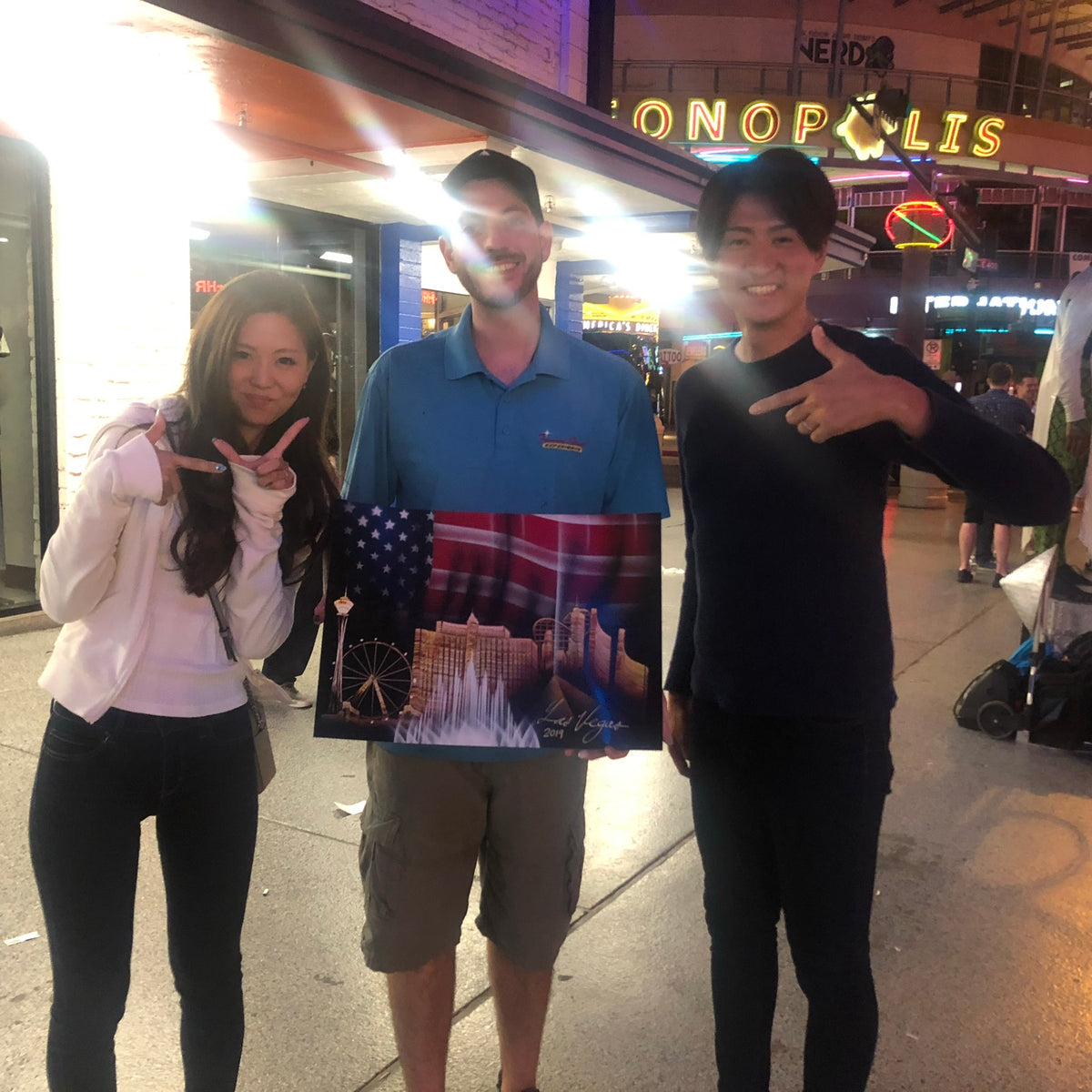 Happy collectors holding a Las Vegas original painting